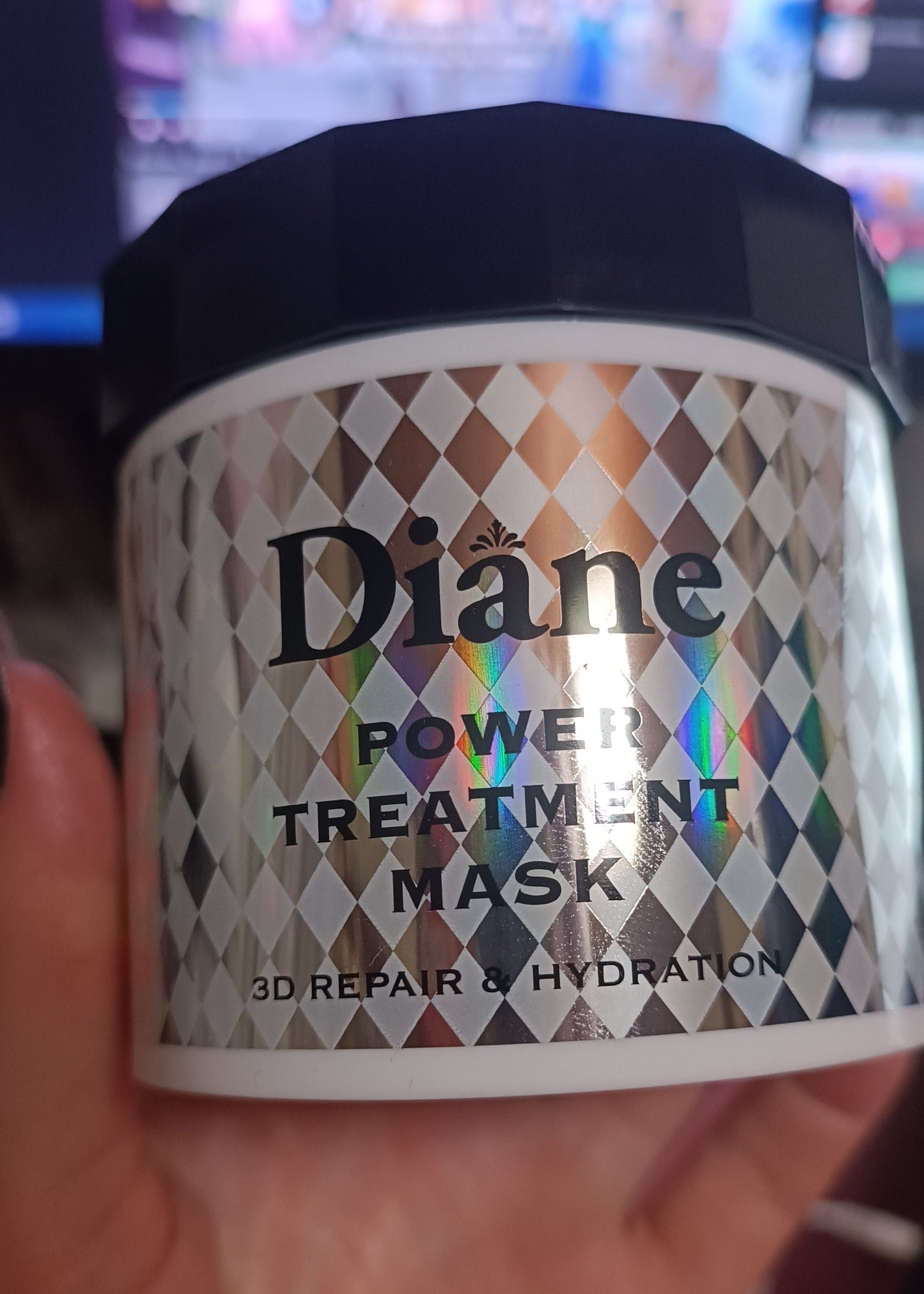 Diane Power Treatment Mask jar held in a hand with a blurred background