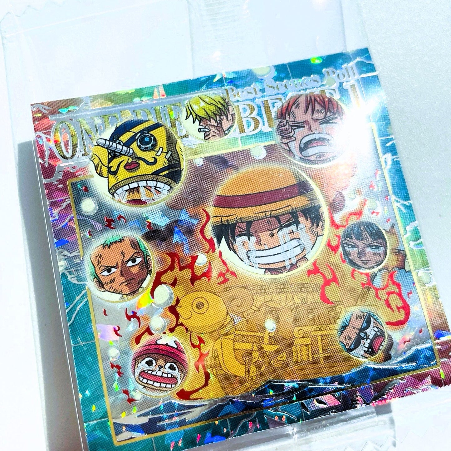 Card featuring two animated characters with 'One Piece' branding on a gold and blue background.