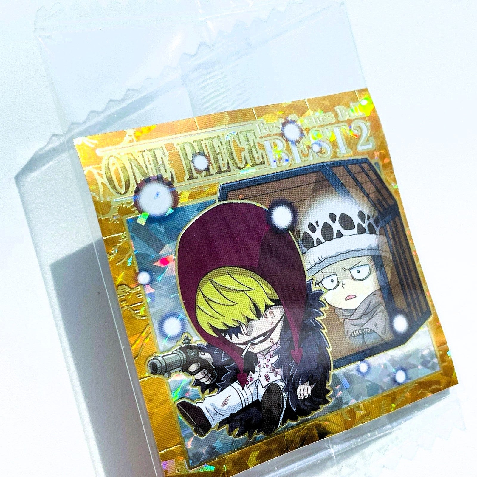 Card with anime-style illustration of a character with purple hair and another character in the background, enclosed in clear packaging.