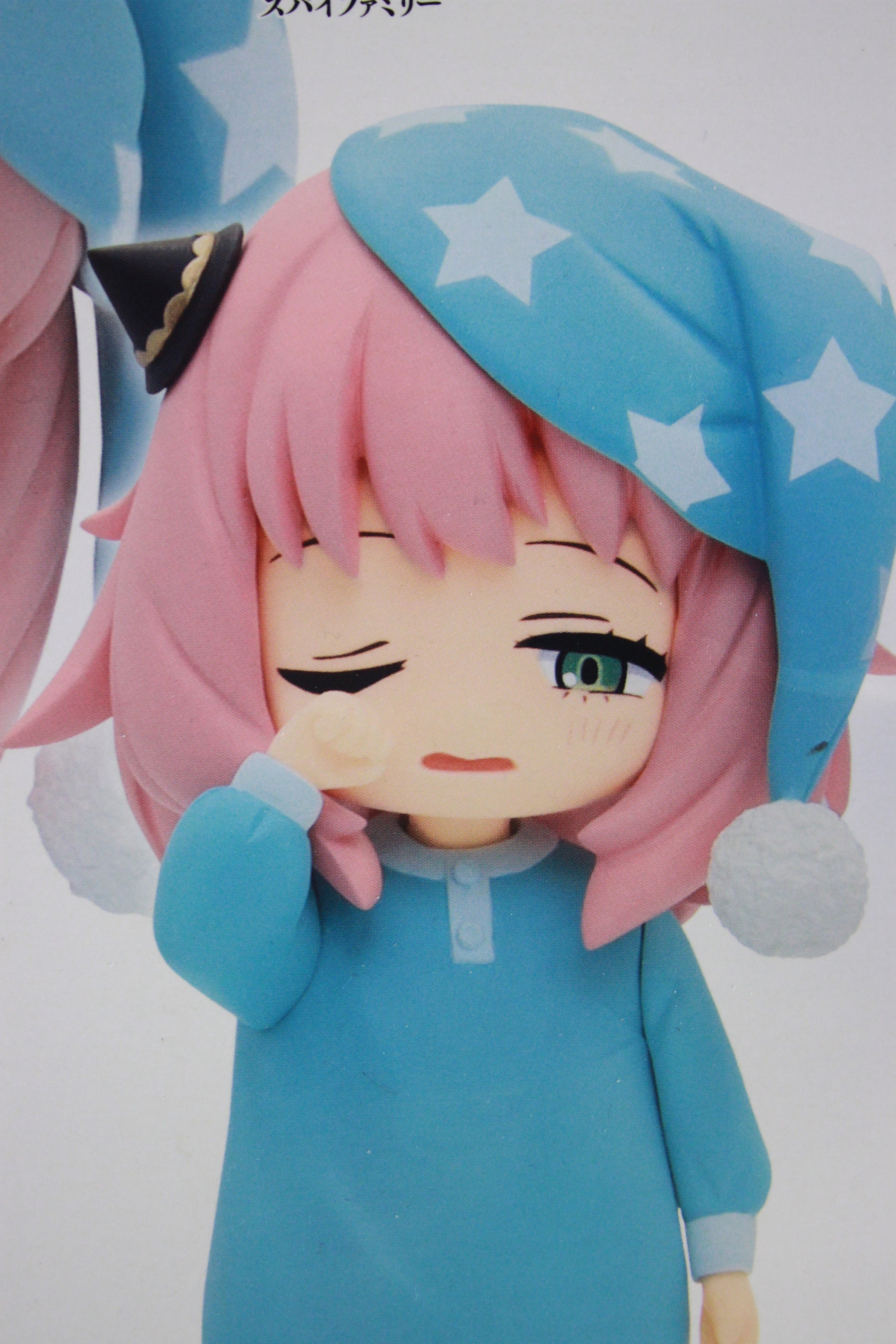 Anime character figurine with pink hair and blue outfit on a white background