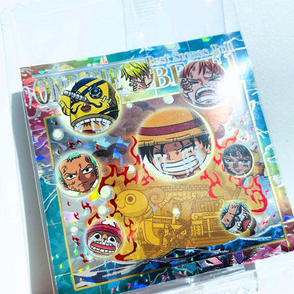 Card featuring two animated characters with 'One Piece' branding on a gold and blue background.
